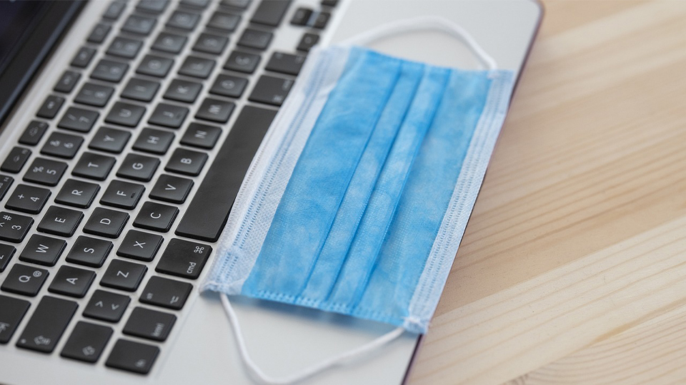 A  face mask on top of a laptop
