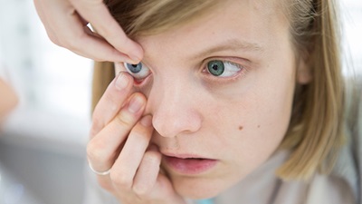girl inserting contact lenses