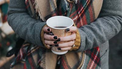 A woman holding a hot drink