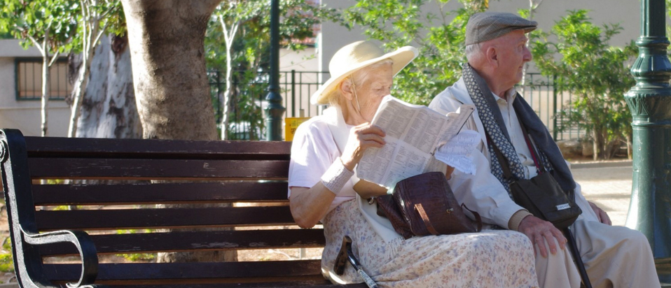 An elderly couple sitting on a bench