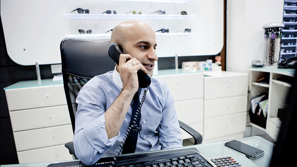 A male optometrist on the telephone