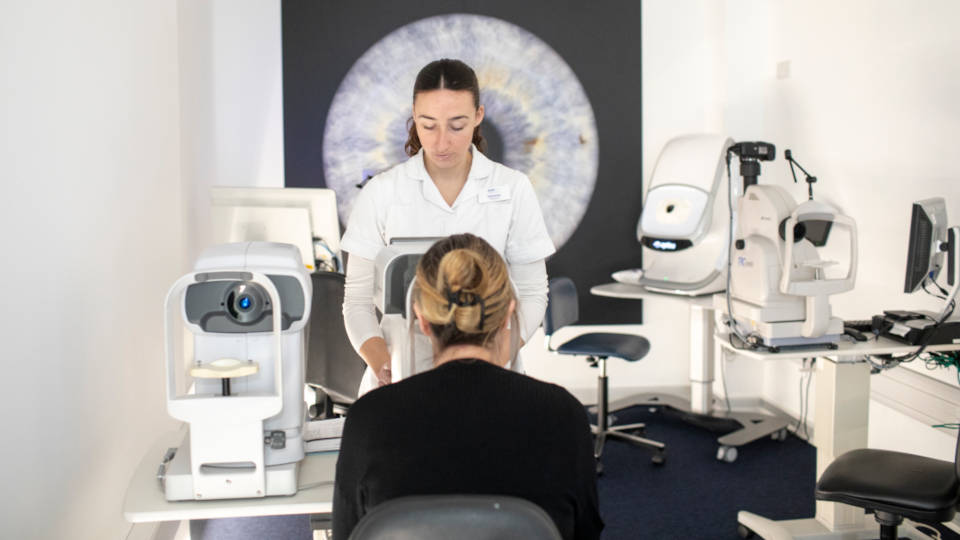 An eye exam or pre-screening is taking place at an optometry practice 