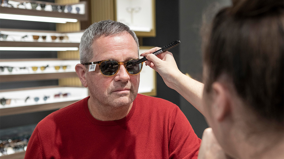 Optometrist checking spectacles on patient