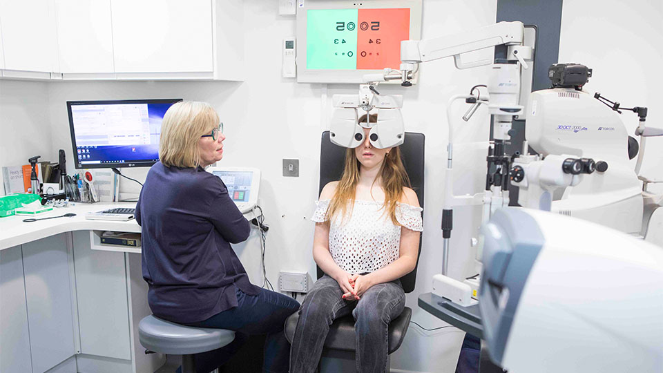 Optometrist examining patient's eyes