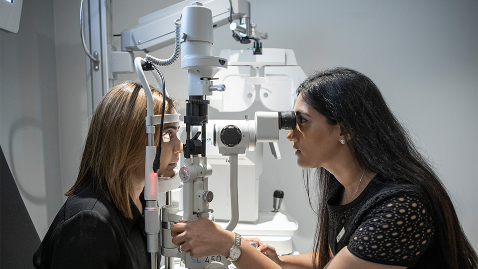 Optometrist examining patient's eyes