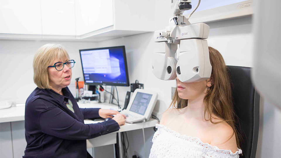 Optometrist examining patient's eyes