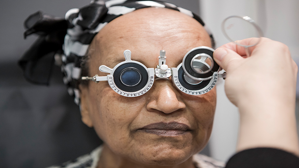 Optometrist using an optometer to measure patients eyes