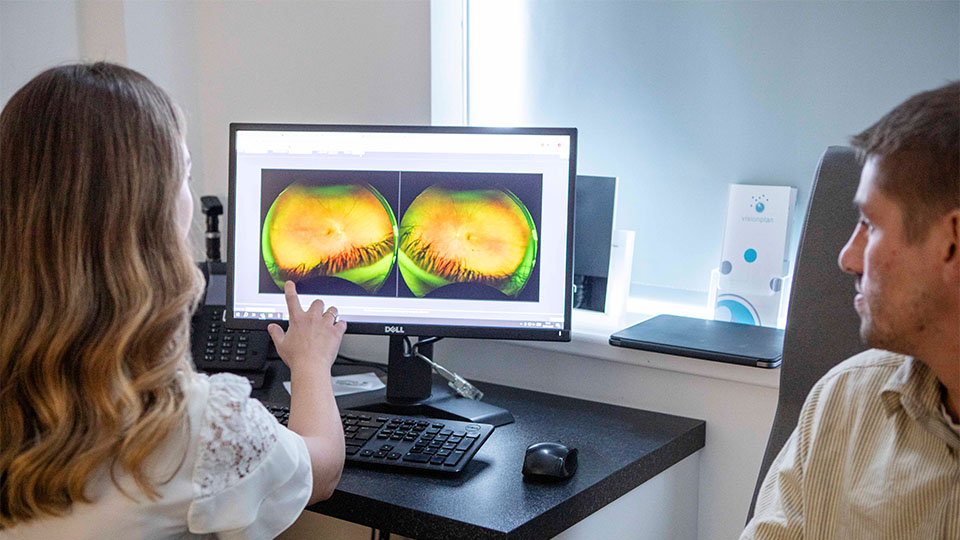 Optometrist looking at patient's eyes on the computer