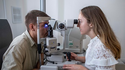 Optometrist looking at patient's eyes