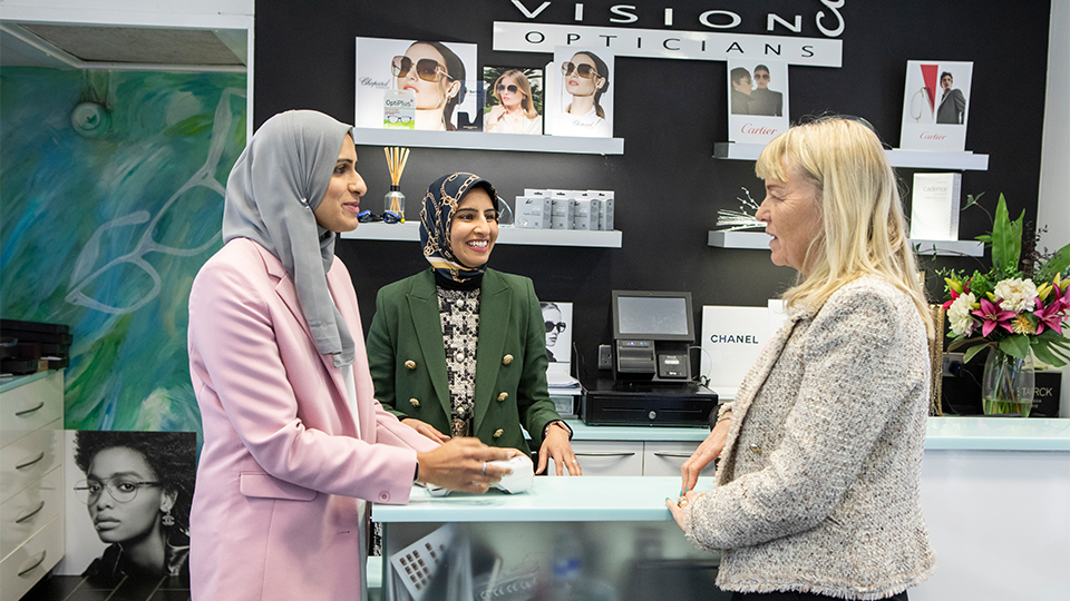 Optometrists speaking with patient at the practice