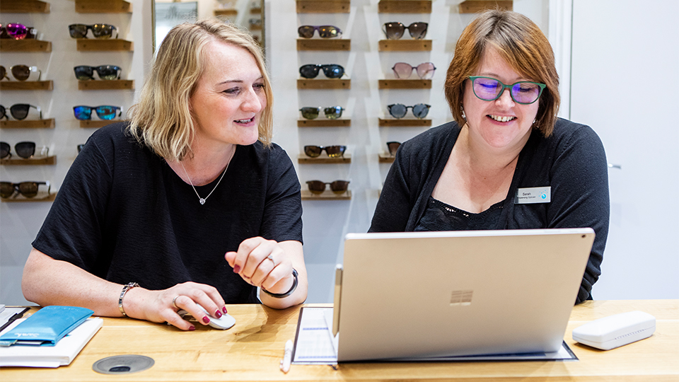 Optometrists looking at laptop