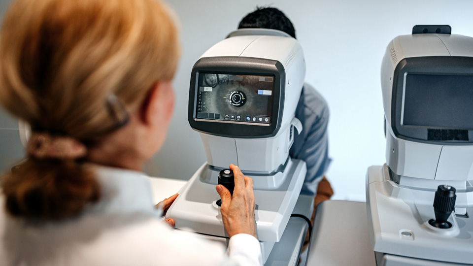 Optometrist examining patient's eyes in ophthalmology clinic.
