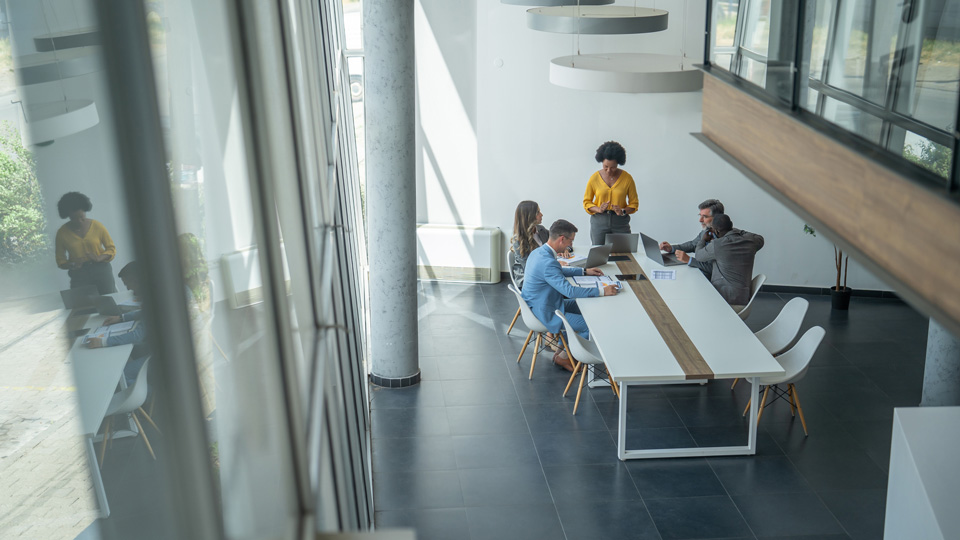 A group of professionals hold a meeting in a conference room