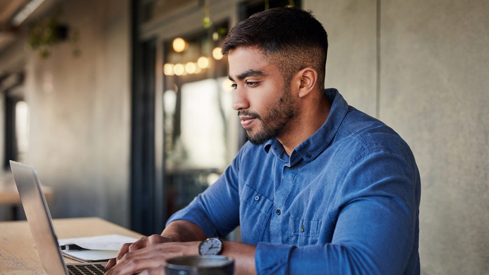 Man sitting at desk working on a laptop