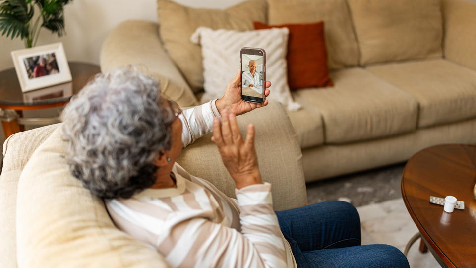 Senior woman talking on video call during telemedice at home