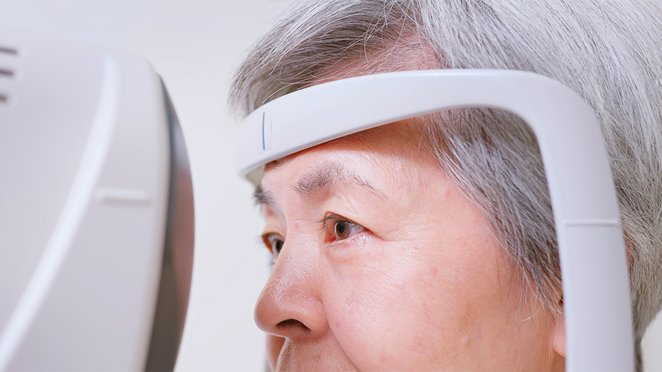 A close up of an older woman receiving an eye test