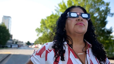 Woman in solar eclipse protecting sunglasses