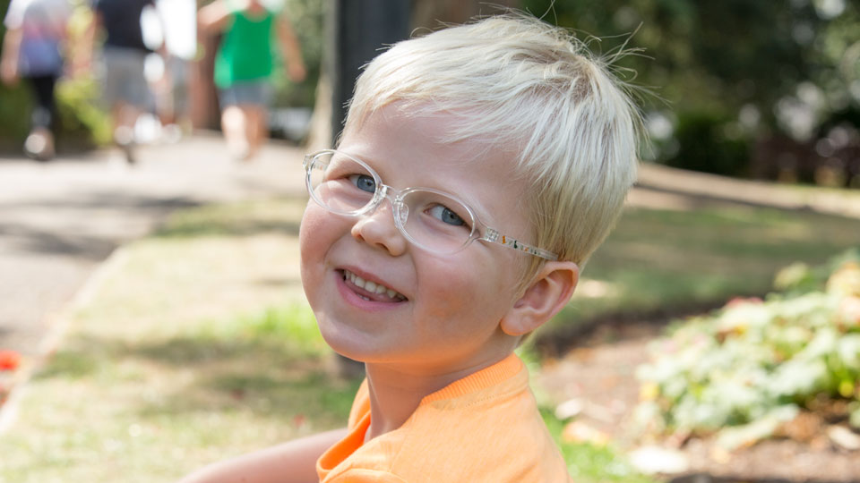 Little boy wearing glasses with dinosaur frames