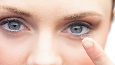 Woman with contact lens on finger