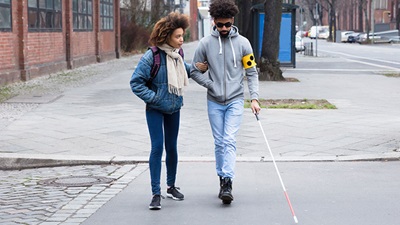 A blind man walking down the street