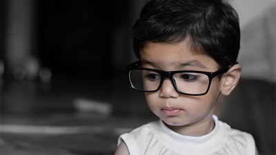A young child wearing spectacles