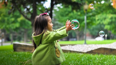 girl catching bubbles