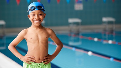 child standing next to a swimming pool
