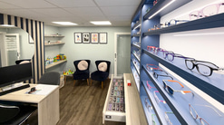 Inside the practice - in the corner are two armchairs, a playtable, and a shelf of toys