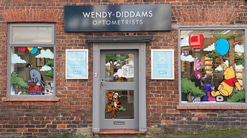 The outside of the practice with illustrations from the Winnie the Pooh story in the windows