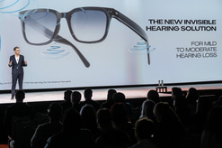 A presenter stands before an image of the Nuance Audio