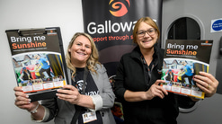Two women each holding a magazine 