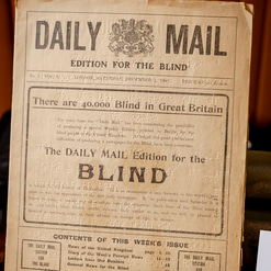 A copy of the Daily Mail in braille from 1906 is displayed on a table
