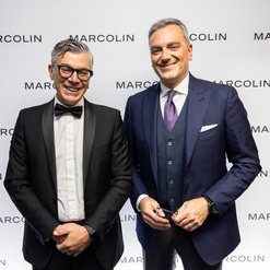 Domenico Bellantone, consul general, and Fabrizio Curci, CEO of Marcolin, pose in front of a Marcolin brand wall 