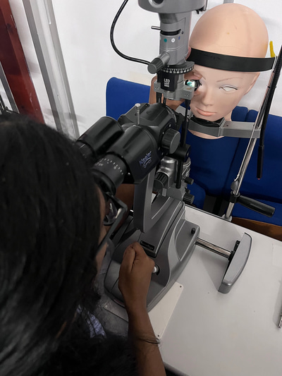 Narthika practises on a slit lamp and volk lens with a model head