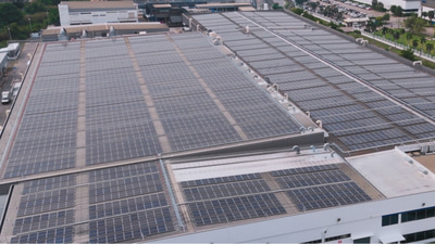 A vast sea of solar panels on the roof of an industrial factory building