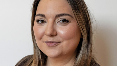 Headshot of Emily Tyler, who has long brown hair