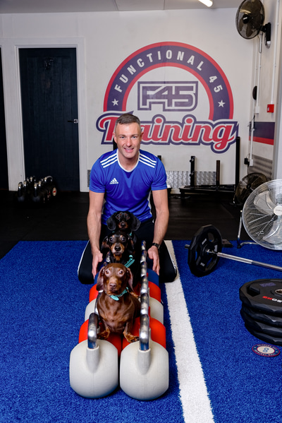 Neil Retallic is pictured at the gym with his three dogs