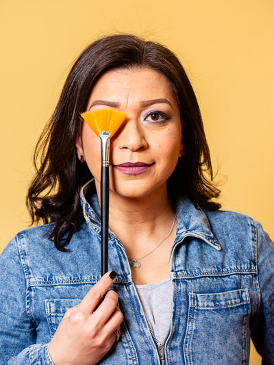 Dispensing optician and practice director, Shabnam Fazl, holds a paint brush over her eye