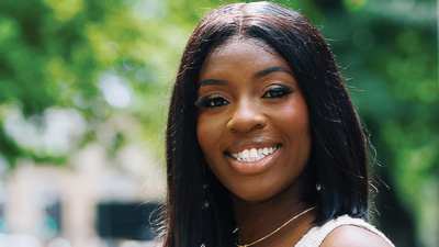 A headshot of Nora Amoakohene smiling at the camera