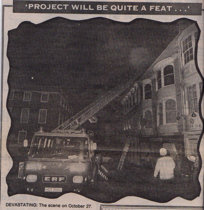 A cutting from an old newspaper showing a photograph of a fire engine, its ladder extended towards a building. On the ground, several firefighters are at work