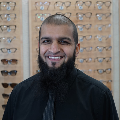 A man with a black beard, smiling