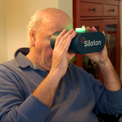 An older man uses looks through a Siloton-branded headset