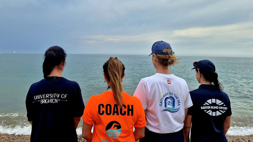 A group of swimmers look out at the ocean