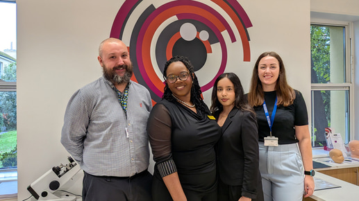 Four people – two clinic leads and two optometry students – stand together in the new eye care centre