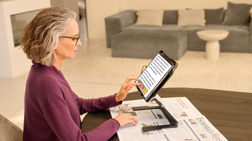 An older woman uses a device which increases font size