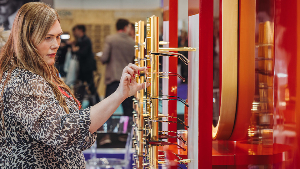 A woman looking at some spectacles at 100% Optical
