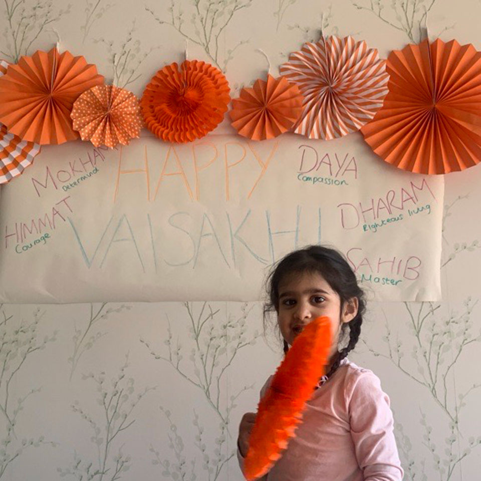 Sansaar Kaur below a Vaisakhi banner with orange decorations