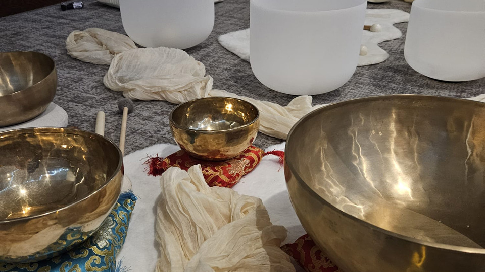 Laid out on the floor is a ring of tall white glass bowls and several low metal bowls