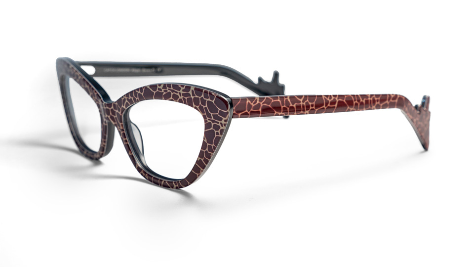 The cat’s eye frame is printed with a giraffe pattern, and the end tips are shaped like a giraffe silhouette.