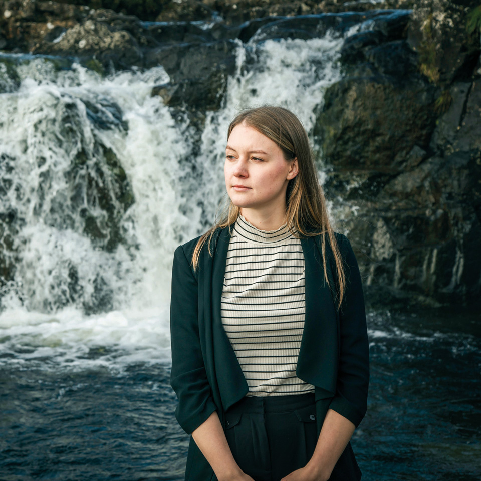 Optometrist Hannah Einarson is photographed in front of a waterfall on the Isle of Skye